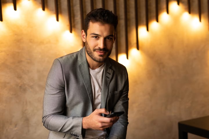 smiling man in suit with phone