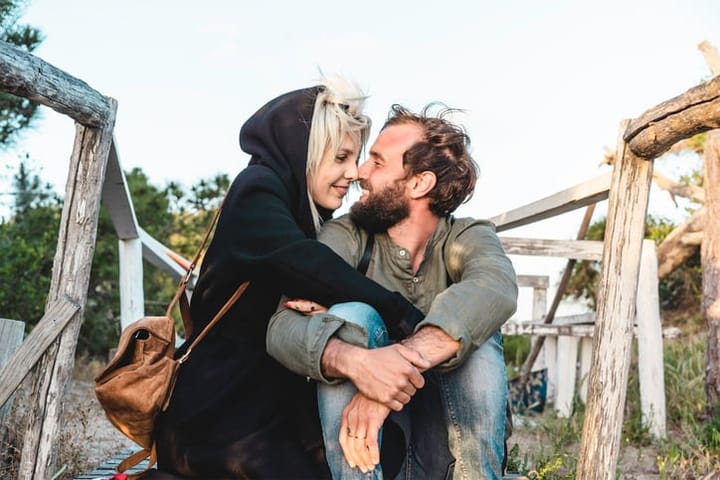 couple sitting on a bridge