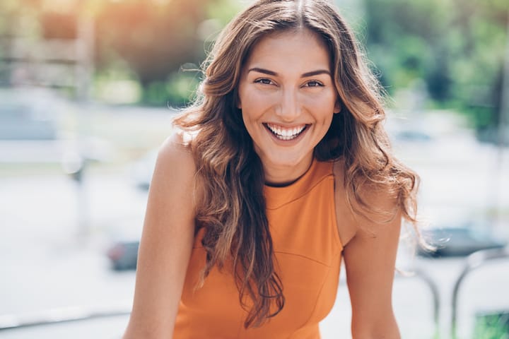 woman smiling in orange dress