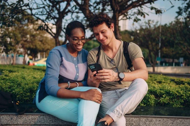 couple looking at phone outdoors