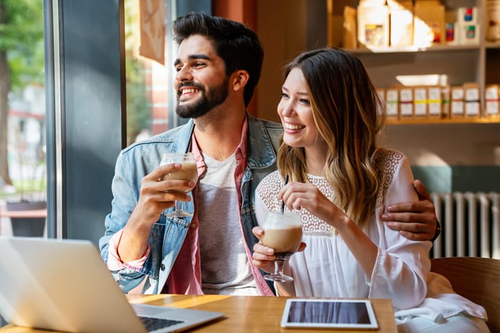 young couple smiling drinking coffee
