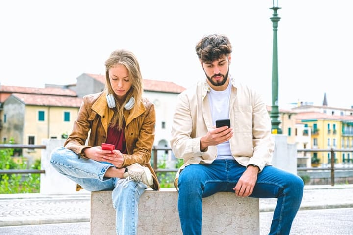 man and woman on their phones outside