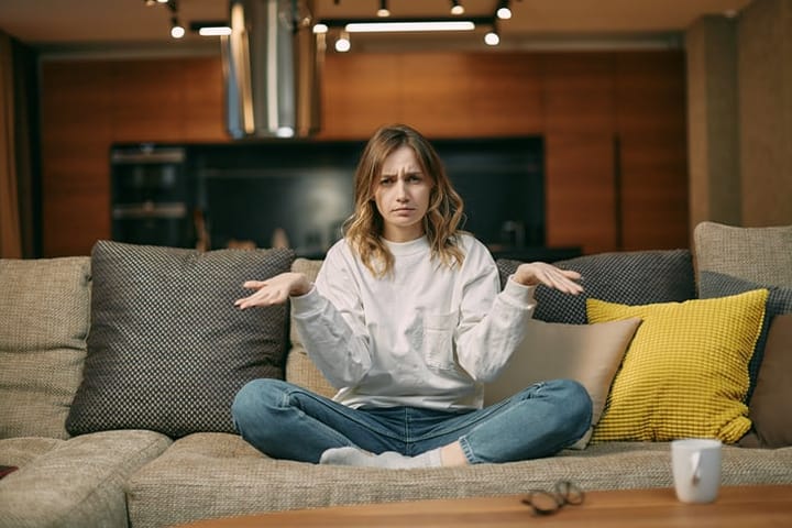 woman sitting on the couch confused