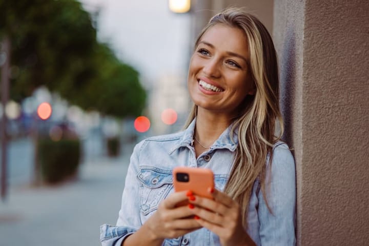 long haired blonde woman holding mobile