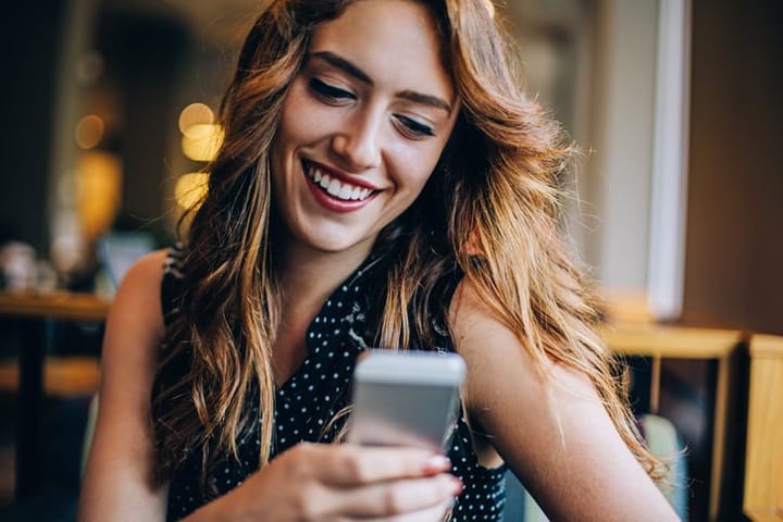 attractive woman smiling at mobile