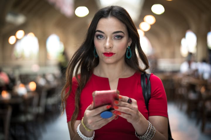 brunette woman using mobile in red