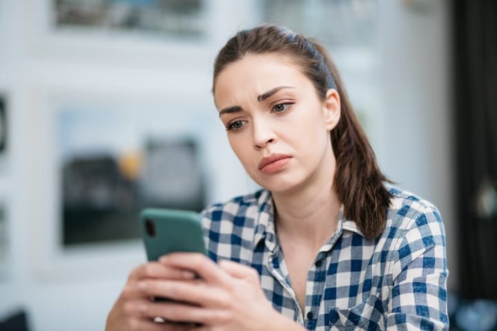 closeup sad young woman texting