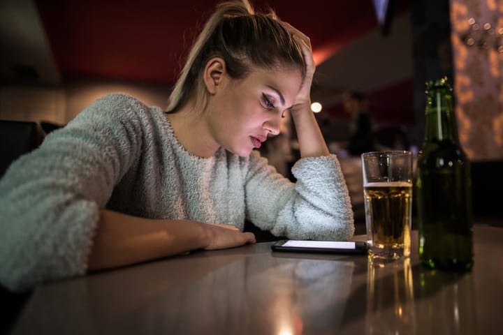 sad woman alone at bar