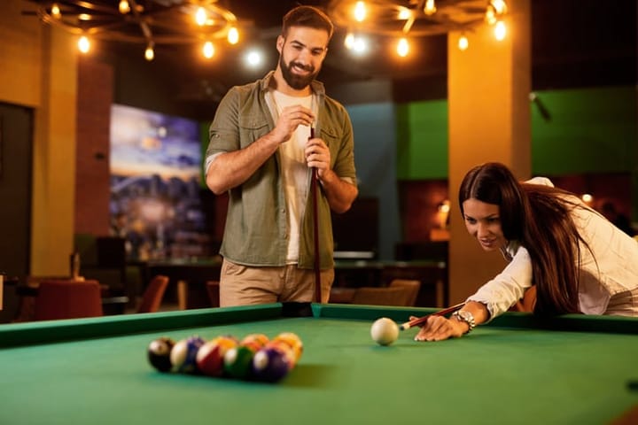 couple playing pool at bar