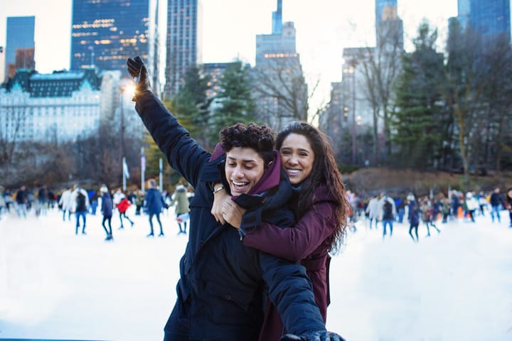 happy couple ice skating outdoors