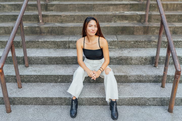 young woman sitting on cement stairs
