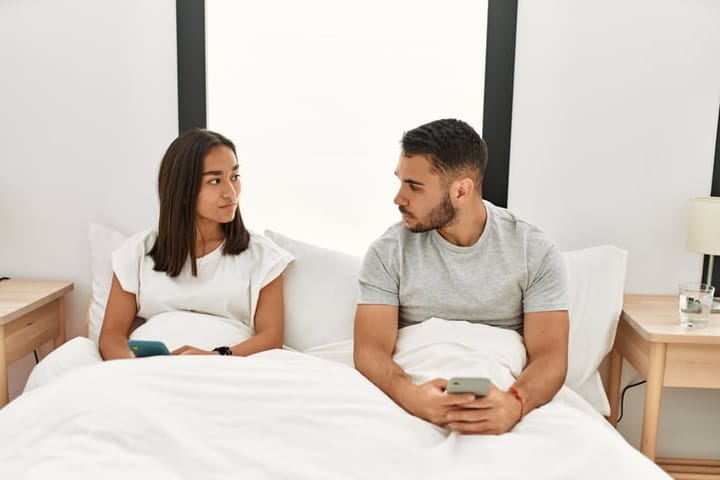 upset couple talking in bed