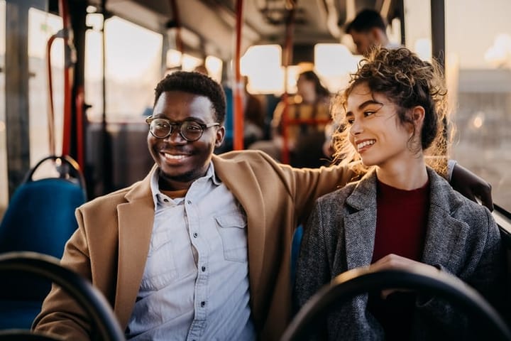 smiling couple riding bus together