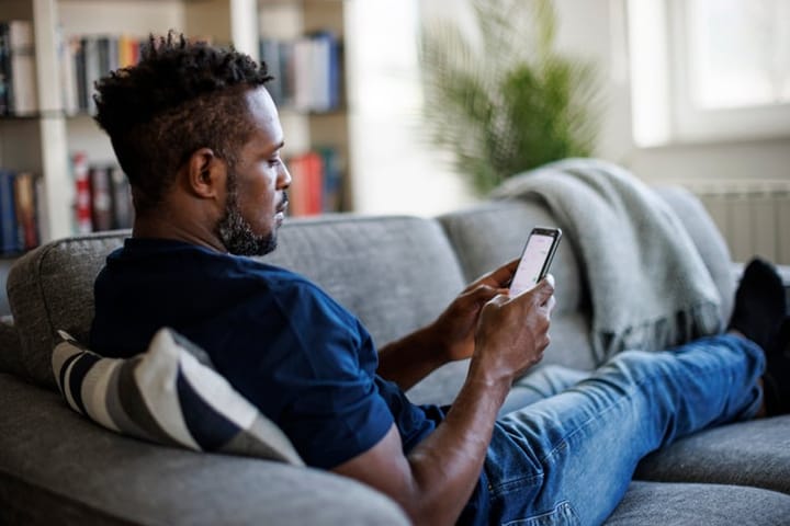 man texting on couch