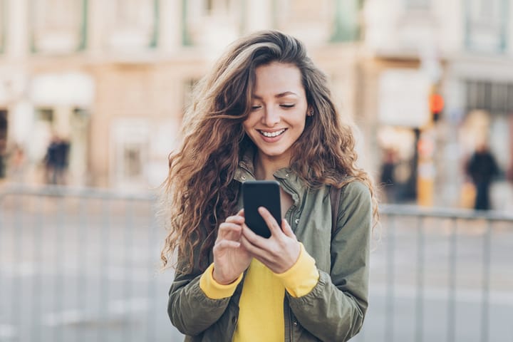young woman texting outside