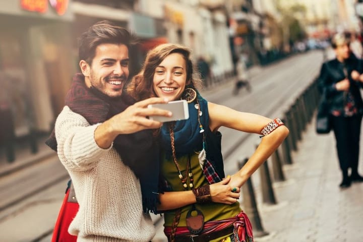 couple taking selfie on city street