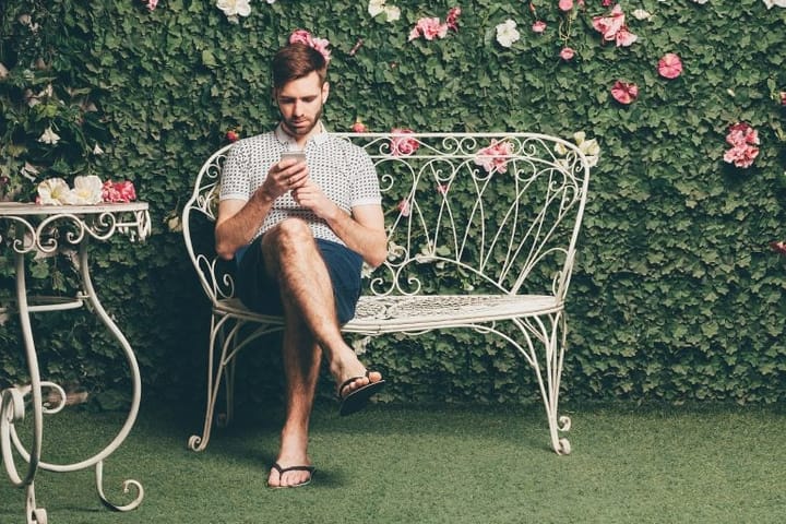 man in flip flops on garden furniture