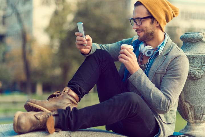 handsome man yellow beanie using mobile