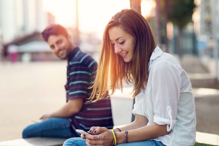 Man flirting with a girl sitting on a close bench