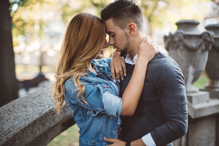 couple kissing by park tree
