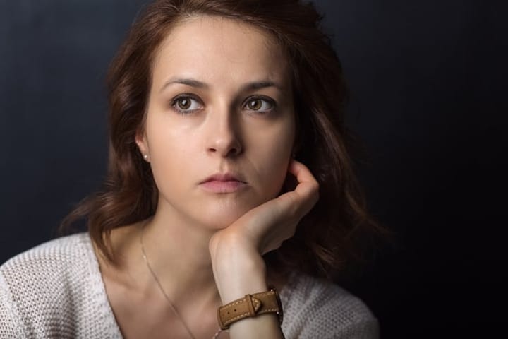 Thoughtful woman against black background