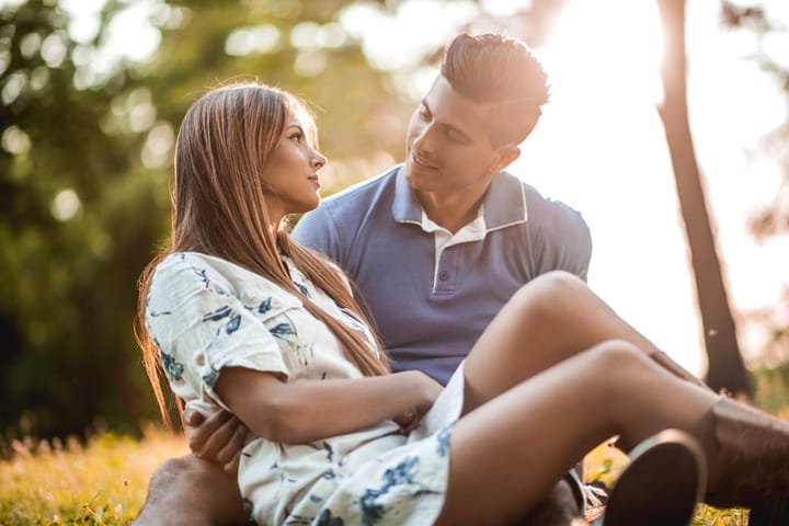 Loving couple relaxing at the park and talking to each other.