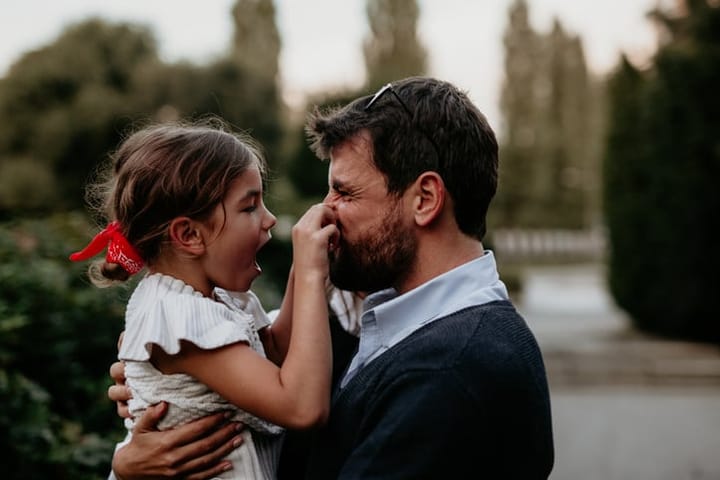 dad with young daughter being silly