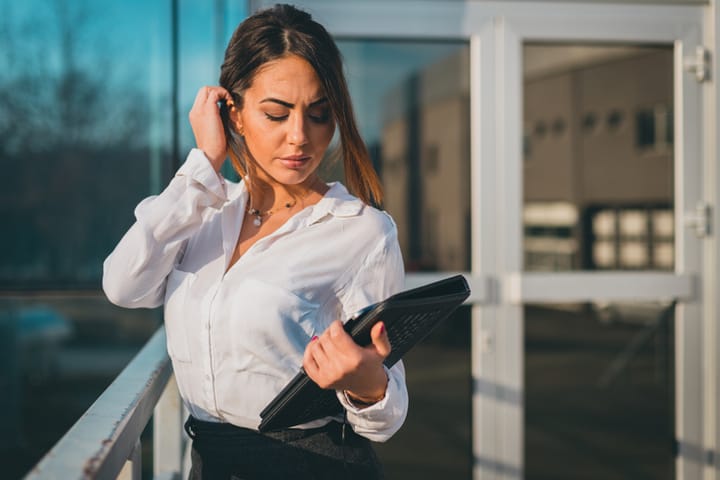 Young formalwear businesswoman carrying digital tablet outdoors