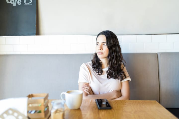 woman looking pensive at cafe
