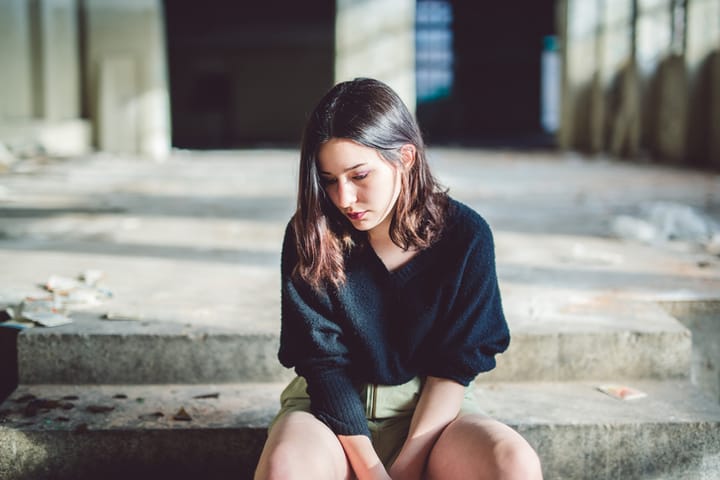 sad woman sitting in bedroom