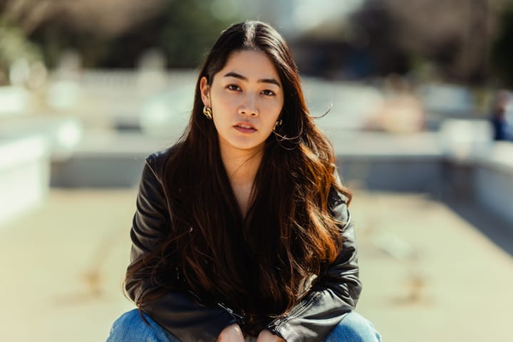 asian woman sitting black leather jacket