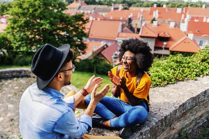 happy couple sitting on outdoor ledge