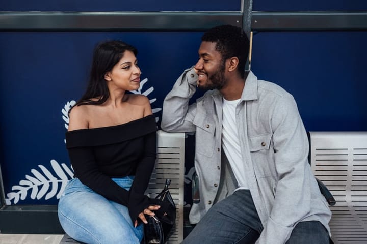happy couple talking on bench
