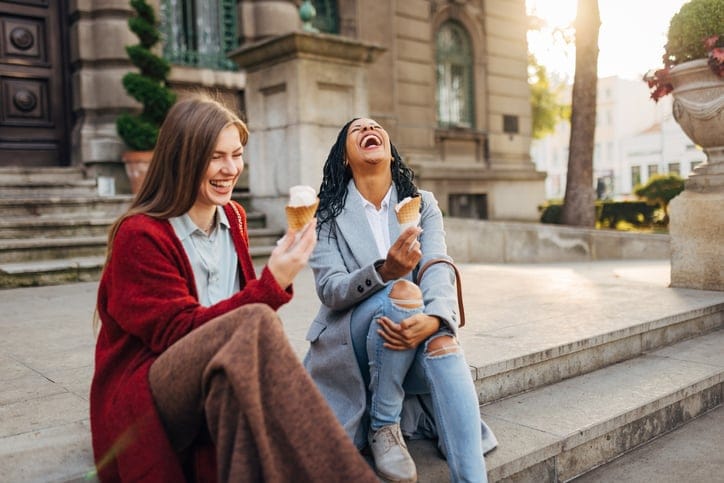 young female friends laughing ice cream