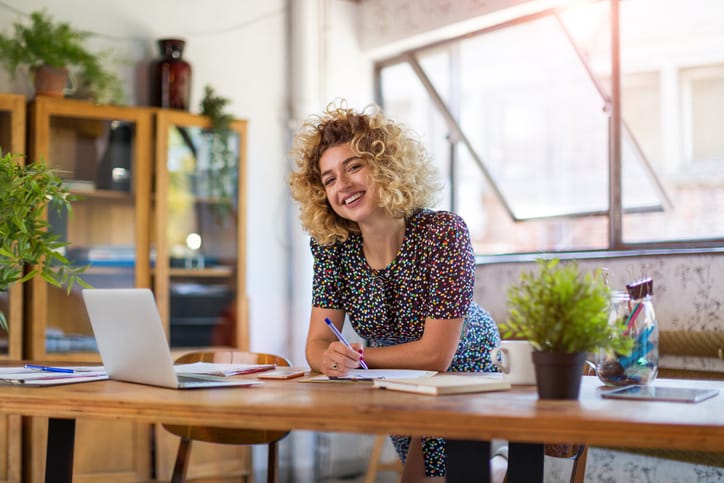 woman smiling standing at desk