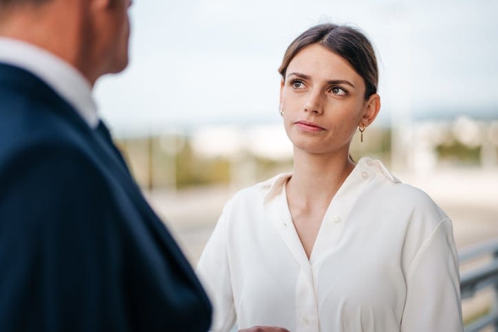 woman looking at man with annoyed expression