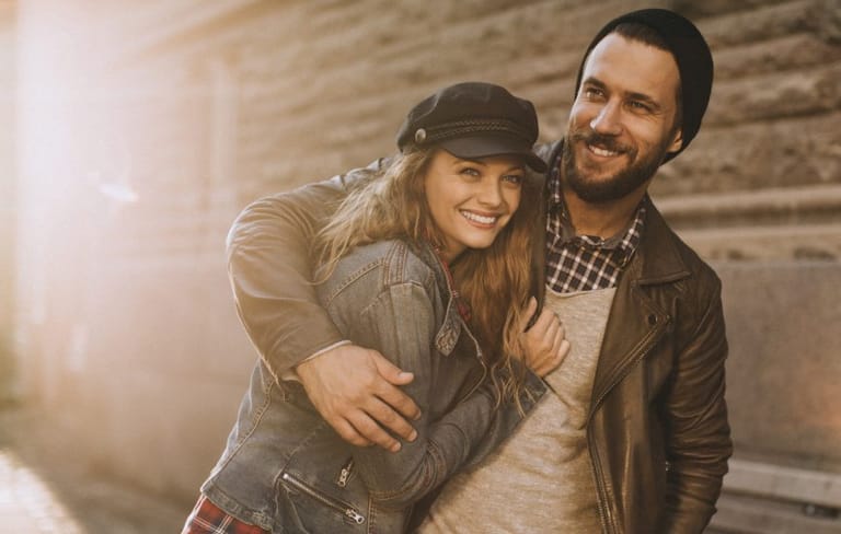 Couple in leather jackets smiling and embracing