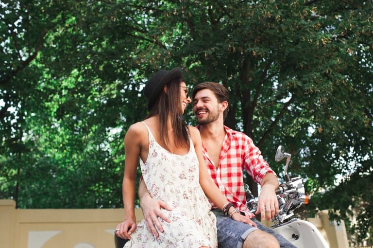 happy couple cuddling in sunny park