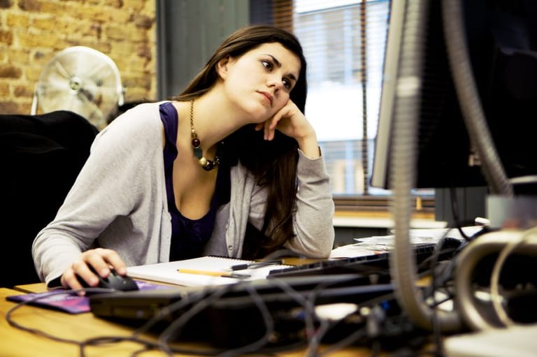 Female office worker staring at computer.