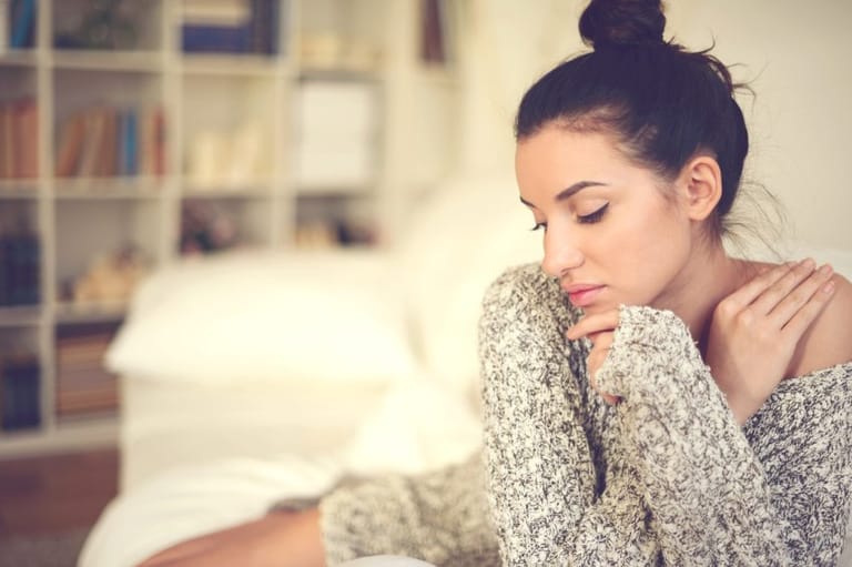 sad brunette woman on couch