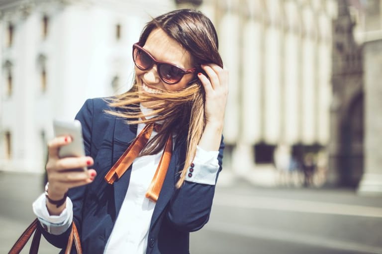 classy woman texting on windy day