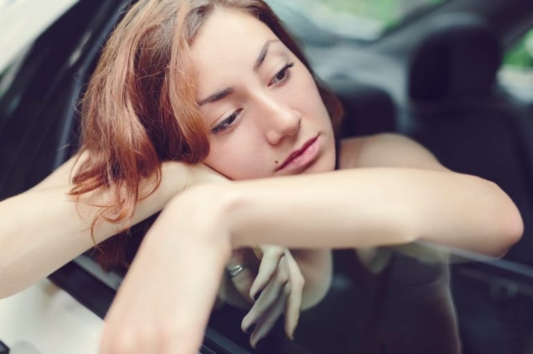 sad hipster woman in car