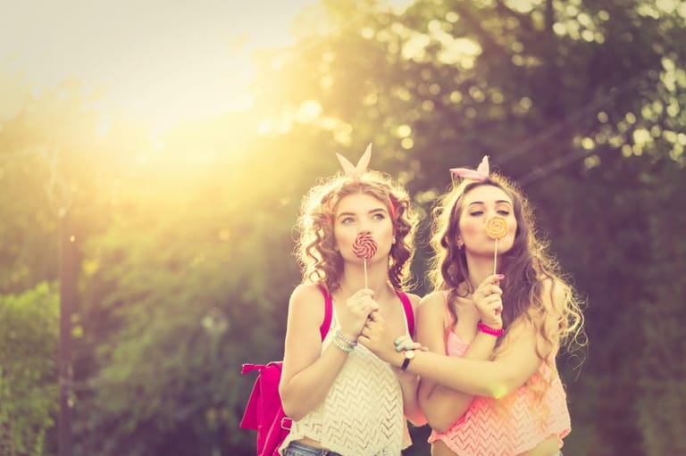 curly-haired women with lollipops outdoors