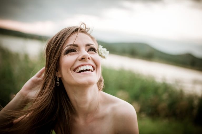 brunette woman with flower in hair outdoors