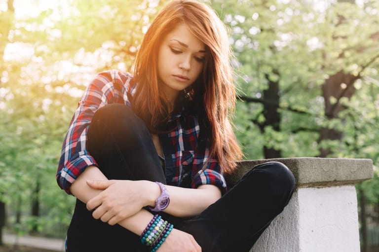 sad teen girl alone at park