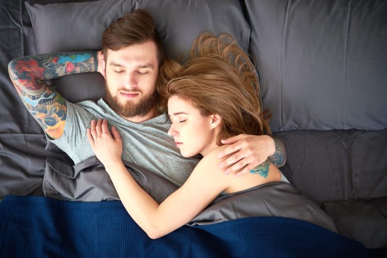 Young sleeping couple laying in bed