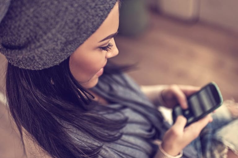 Smiling woman using smartphone