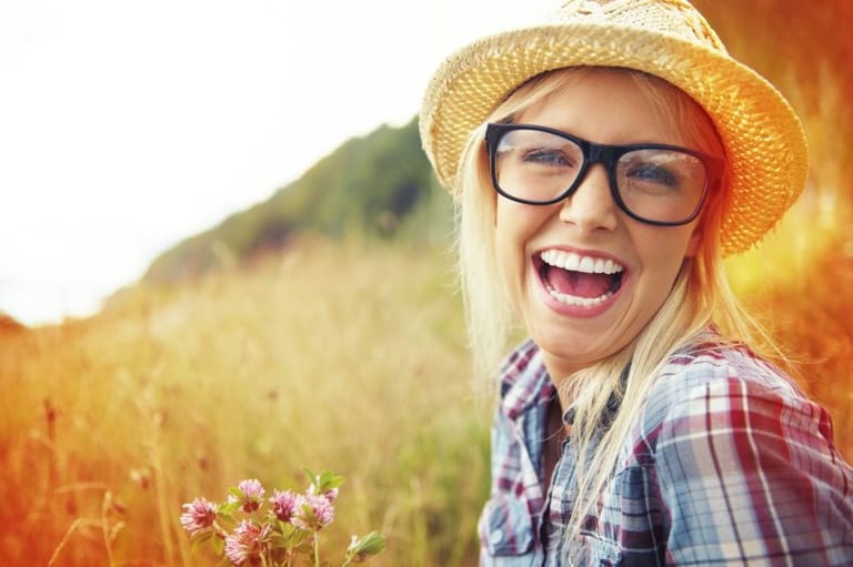 Smiling woman in glasses in field