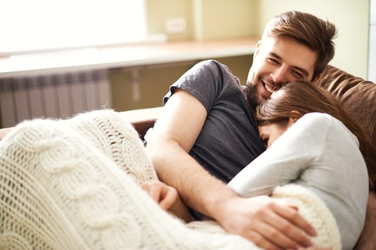 Young couple embracing on sofa