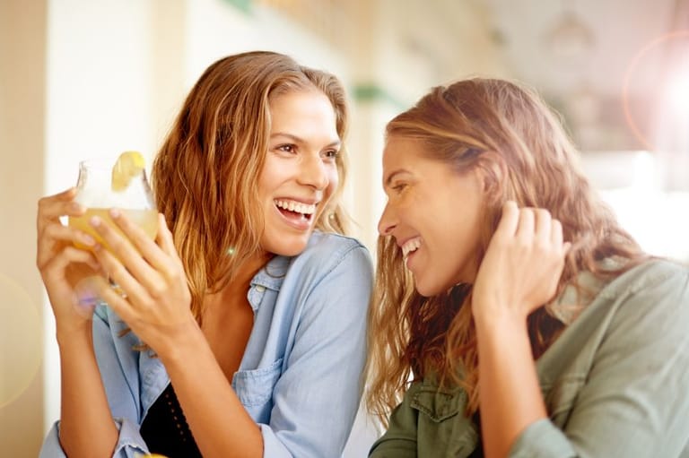 Female friends laughing on sunny day
